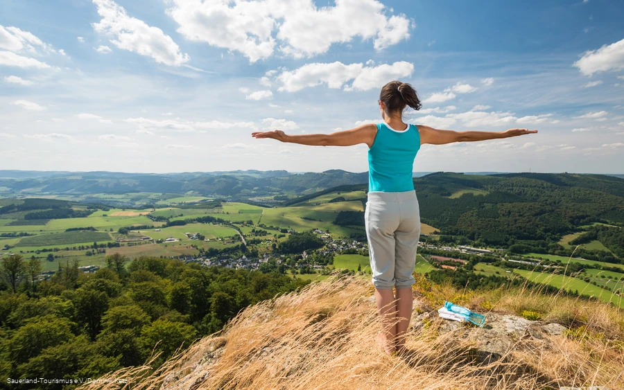 A woman enjoys the sweeping view from the Bruchhauser Steine