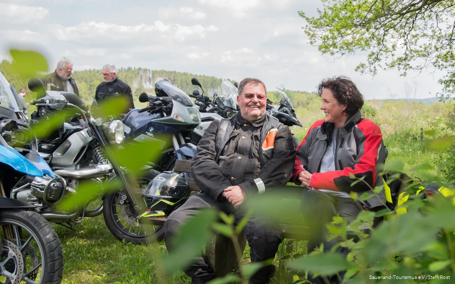Motorrijders pauzeren op een bankje in Sauerland.