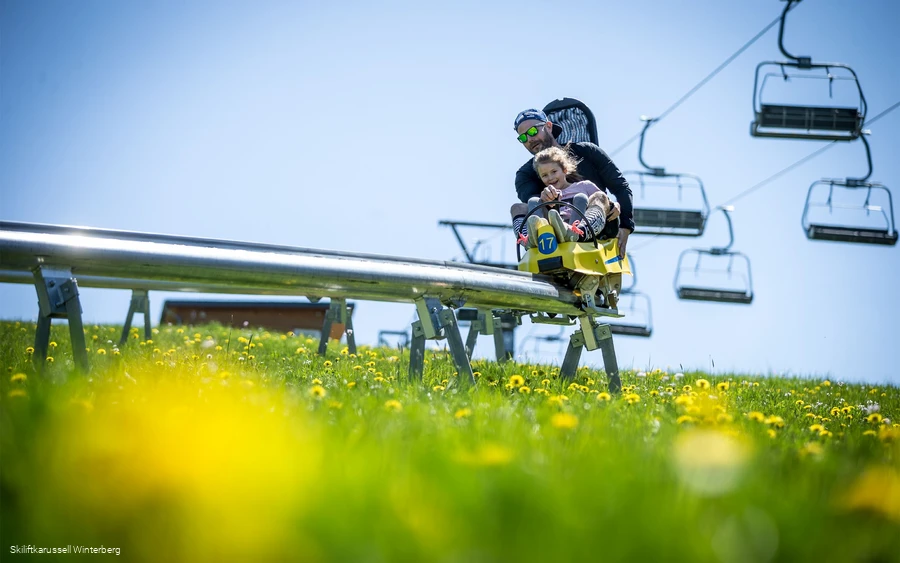 A father rides with his daughter in the Herrloh Blitz in Winterberg.