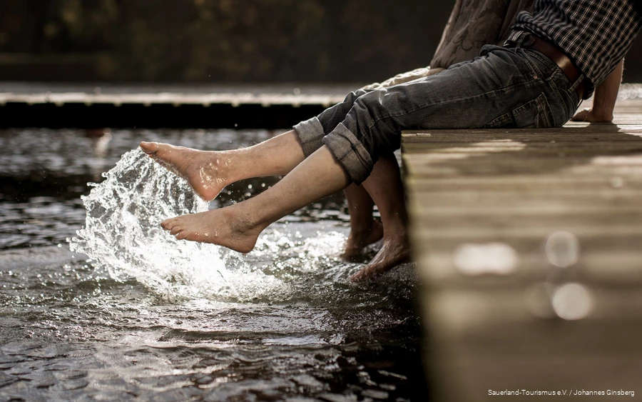 Feet_Water Two excursionists dip their feet into the clear water of a Sauerland lake.