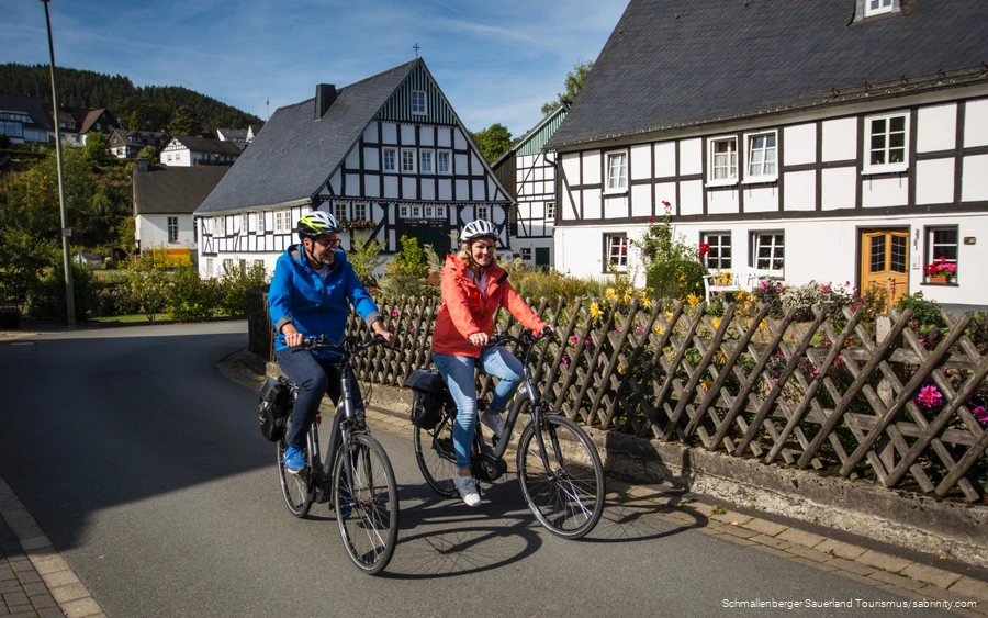 Biketour_Fachwerk Ein Paar unternimmt eine Radtour durch ein Fachwerkdorf.