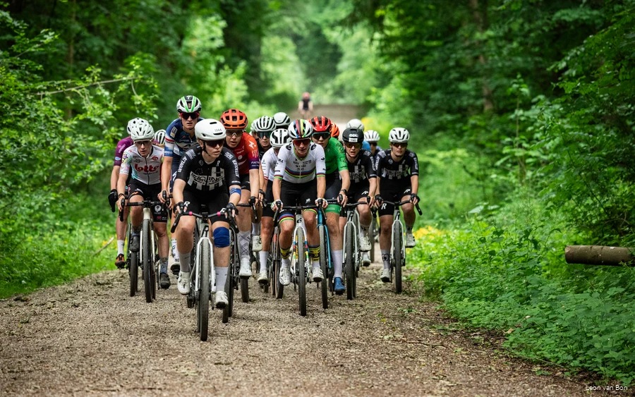 Ein Gruppe Teilnehmer des Gravel-Rennens 3Rides auf einem Schotterweg im Wald.