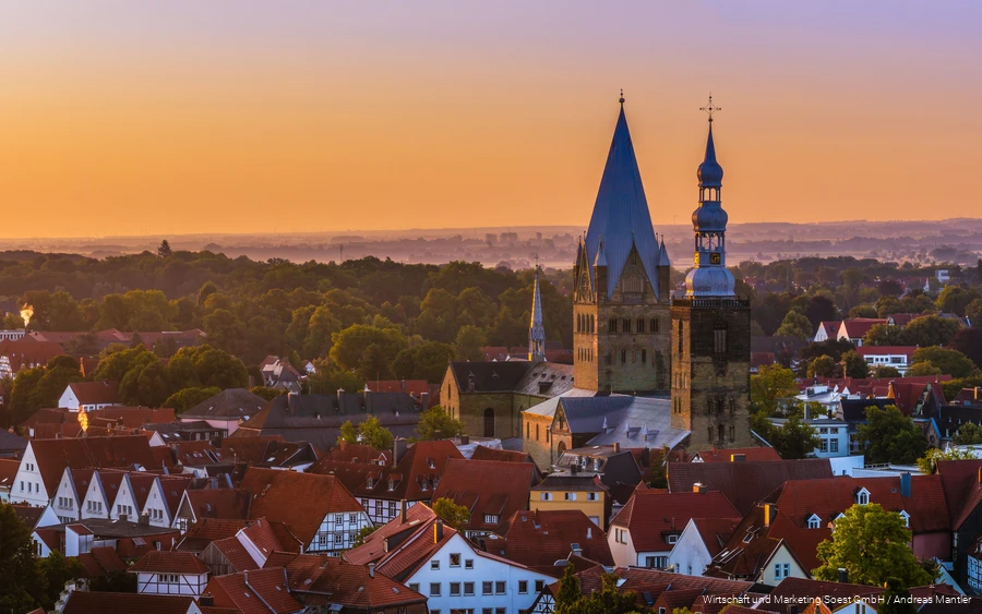 Luftaufnahme von Soest mit Kirche in der Mitte und orangem Sonnenuntergangshimmel