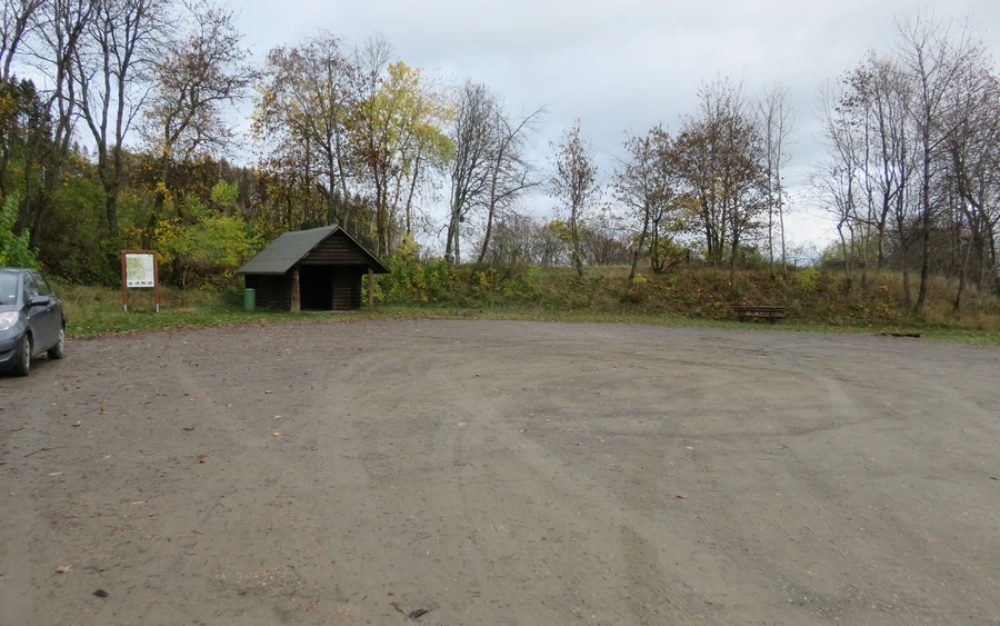 Großer Parkplatz umgeben von Bäumen mit einer kleinen Schutzhütte.