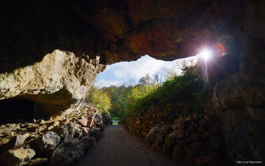 De zon schijnt in de ingang van de Reckenhöhle.
