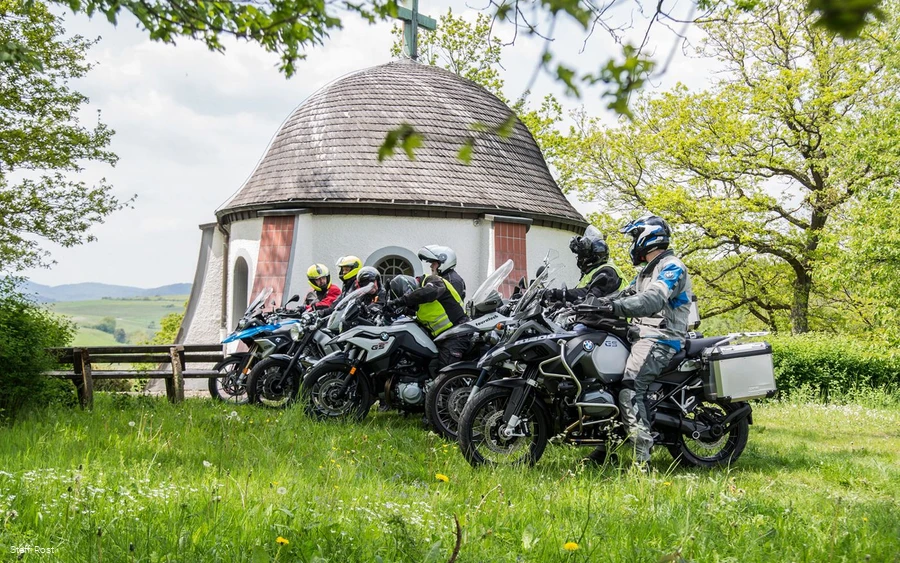 Motorrijden Motorrijders nemen een pauze bij de kapel boven Braunshausen.