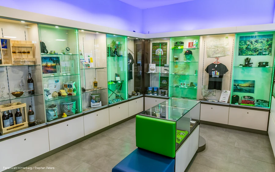 Eine beleuchtete, gläserne Vitrine mit Merchandiseartikeln.