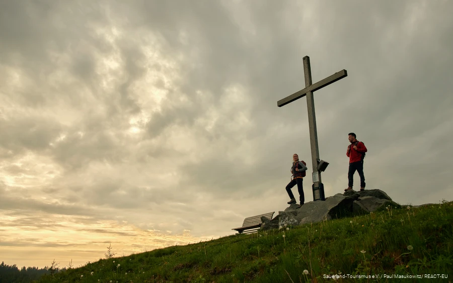 Zwei Wanderer genießen den Sonnenuntergang auf dem Clemensberg.