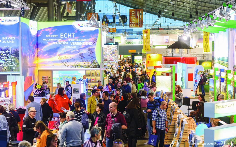 Besucher der Caravan Motor Touristik in Stuttgart strömen durch die Messehalle und an den Ständen der Destinationen vorbei.