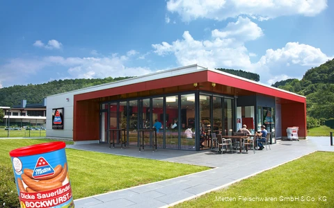 Buitenopname van de Metten factory outlet met een blikje Dicken Sauerland Bockwurst op de voorgrond