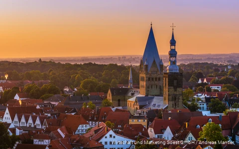 Luftaufnahme von Soest mit Kirche in der Mitte und orangem Sonnenuntergangshimmel