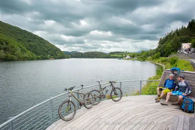 Two mountain bikers take a break on the riverbank