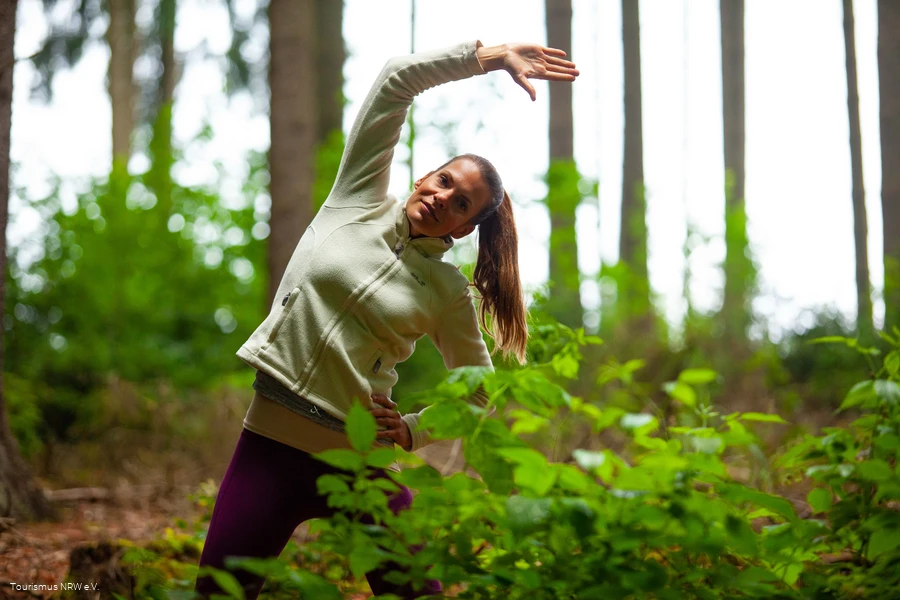 A woman does an exercise in the forest