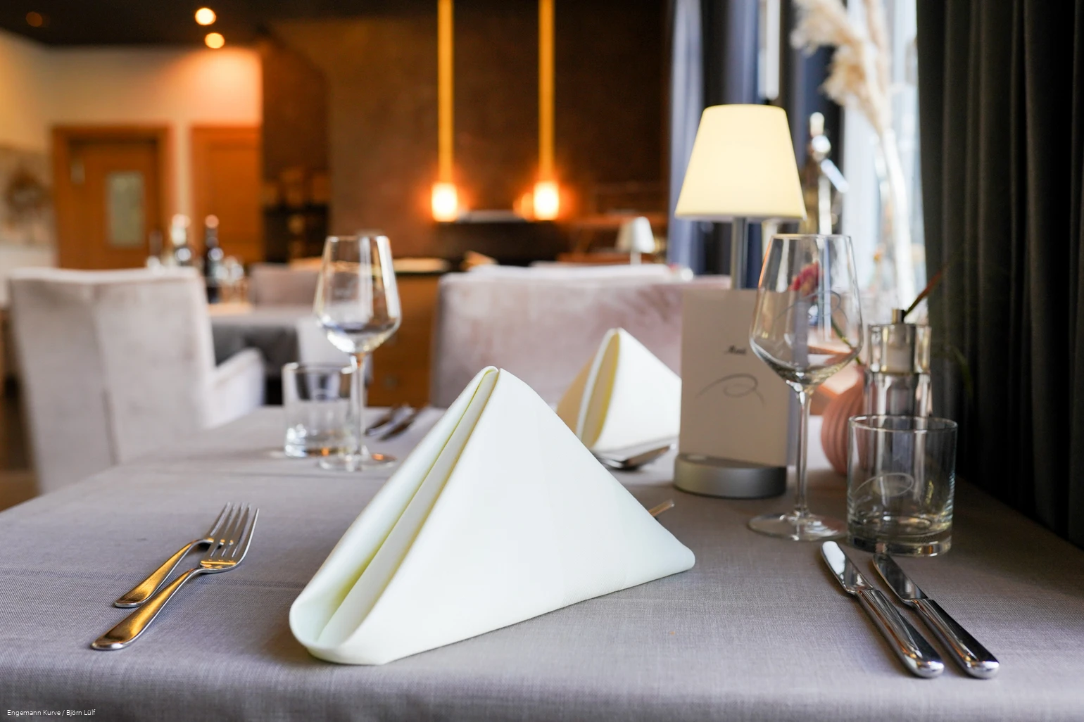Ein mit gefalteten Servietten und Besteck eingedeckter Tisch in einem Restaurant.