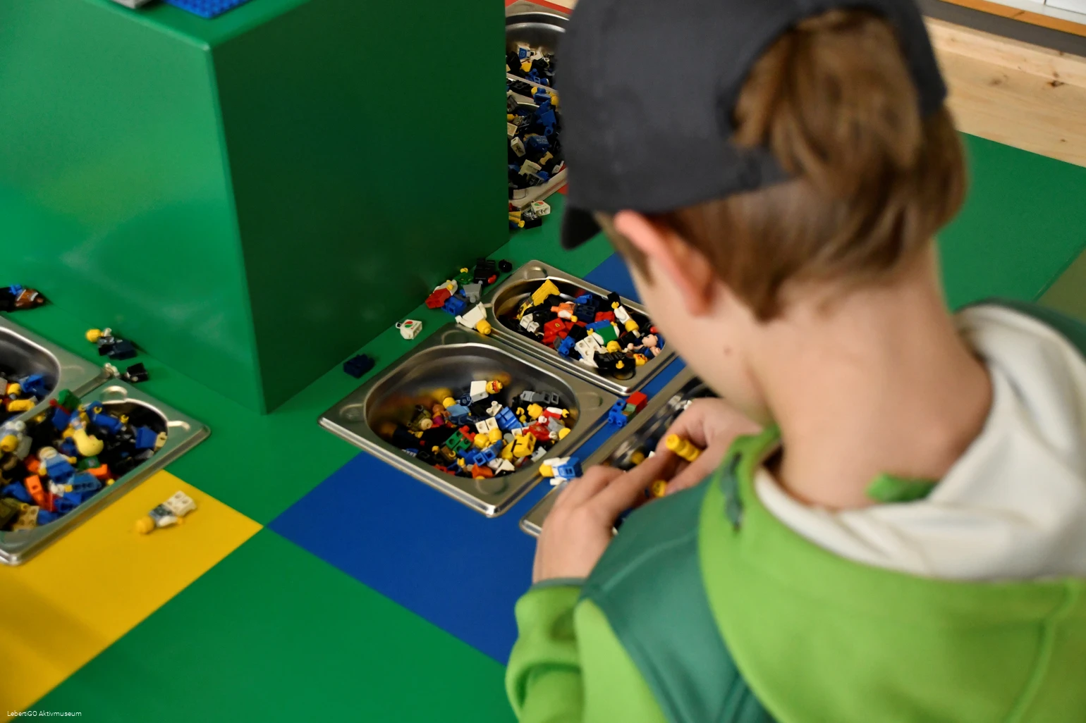 Ein Kind baut etwas aus kleinen Legosteinen.