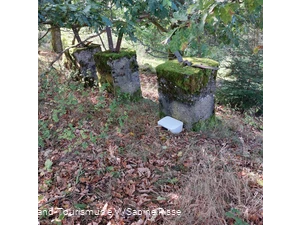 Eine Kiste mit dem Gipfelbuch liegt gut versteckt hinter einem großen Stein