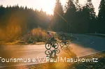 Zwei Rennradfahrer bei Sonnenaufgang auf einer Sepentine