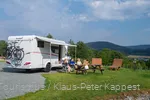Een gezin geniet van hun kampeervakantie op het platteland.