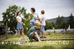 A family playing mini golf at Diemelsee. A son prepares his next shot.