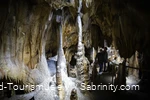 Two women are standing in a stalactite cave.