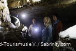 Two women and the cave guide marvel at the cave.