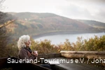 Een vrouw ontspant terwijl ze leest in het herfstlandschap rond de Biggesee.