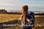 Een vrouw met pet geniet van de zonsopgang op de Kahler Asten en tuurt in de verte