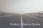 Blick auf eine Autobrücke im Nebel.