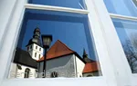 Reflectie van de kerktoren in het raam