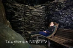 Eine Frau sitzt in der Höhle in Nordenau