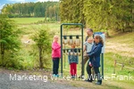 Familie am Kuhglockenspiel auf dem Milch-Erlebnispfad Usseln