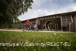 Twee fietsers duwen de fietsen voor het Gradierwerk in Bad Sassendorf