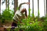 Een vrouw doet een oefening in het bos