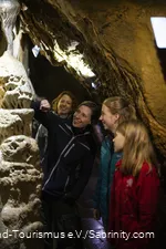 Die Höhlenführerin erklärt zwei Kindern die Tropfsteinhöhle.