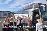 A young tour group in front of the coach.