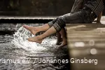 Zwei Ausflügler tauchen ihre Füße ins klare Wasser eines Sauerland-Sees.