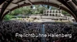 Zahlreiche Zuschauer sitzen überdacht und schauen Richtung Freilichtbühne.