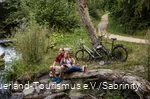 Pärchen macht Rast auf einem Baumstamm an der Möhne