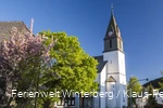 Eine Kirche umgeben von blühenden Bäumen.