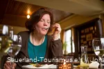 Een vrouw geniet van haar Essen maaltijd in een herberg in Sauerland.