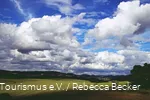 Dicke Wolken am blauen Himmel ziehen über die Sauerländer Landschaft.
