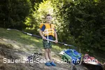 Junge mit Schwimmweste freut sich auf Kanufahrt mit einem Paddel in der Hand.