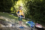 Junge mit Schwimmweste freut sich auf Kanufahrt mit einem Paddel in der Hand.