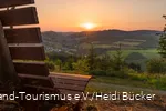 Sonnenuntergang am Hömberg mit Bank im Vordergrund.