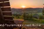 Sonnenuntergang am Hömberg mit Bank im Vordergrund.