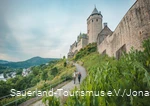 zwei Wanderer gehen unterhalb der Burg Altena