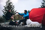 Hund mit zwei Wanderern auf einem Trekkingplatz